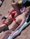 Cute teens tanning in bikinis at the beach