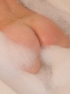 Busty teen shows off her tight round ass in the bubble bath