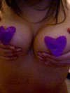 Gina covers her nipples with purple hearts